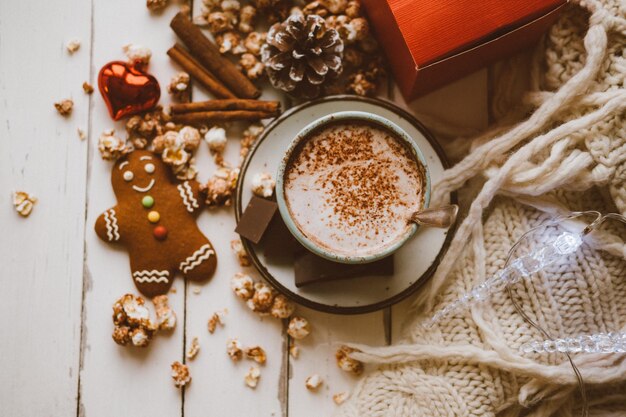 Biscotti allo zenzero con popcorn e cioccolato al cacao e coperta lavorata a maglia Accogliente sfondo della casa invernale