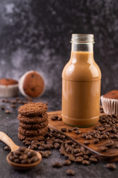 Biscotti con chicchi di caffè disposti su un piatto di legno.