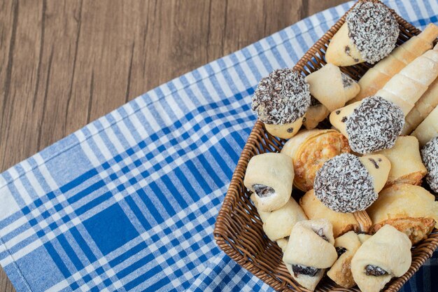 Biscotti con cioccolato e cocco tritato su cesto di legno.