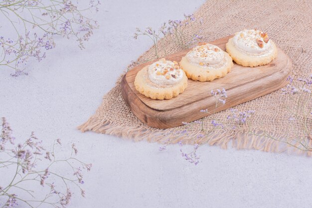 Biscotti croccanti con panna montata su una tavola di legno