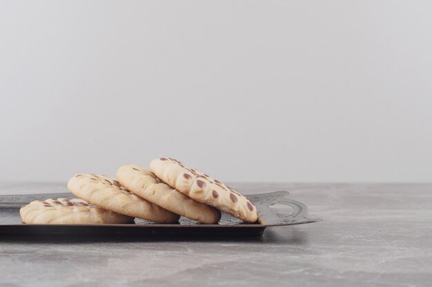 Biscotti croccanti su un vassoio decorato su marmo