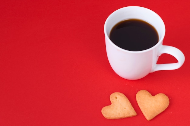 Biscotti cuore con tazza di caffè