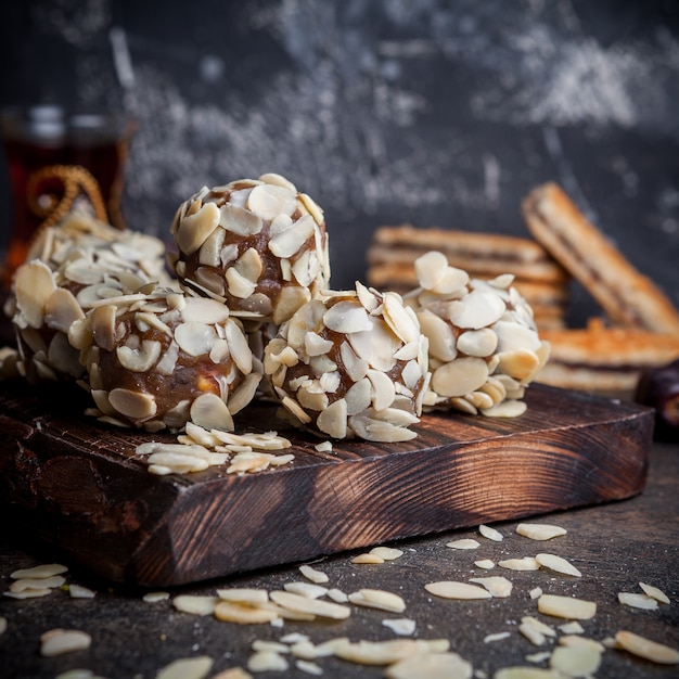 Biscotti del pistacchio di vista laterale su fondo strutturato di legno e nero.