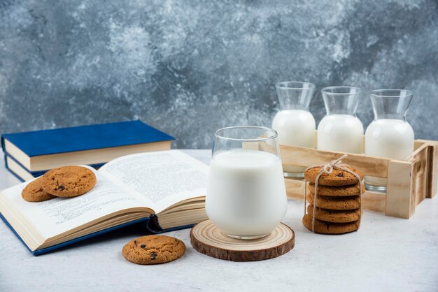 Biscotti deliziosi con bicchiere di latte e libro.