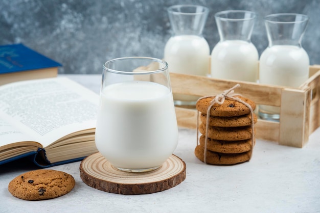 Biscotti deliziosi con bicchiere di latte e libro.