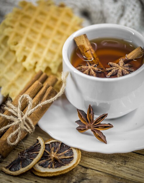 Biscotti deliziosi e tazza di tè caldo con un bastoncino di cannella