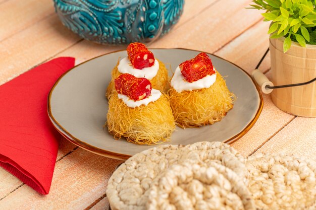 biscotti della pasticceria orientale all'interno del piatto con biscotti crema bianchi su legno