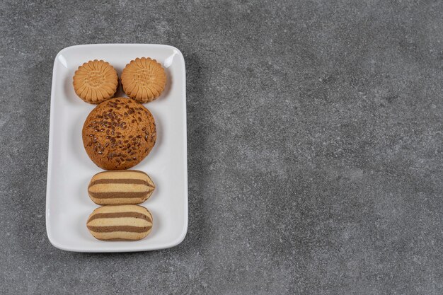 Biscotti dentifrici al piatto sulla superficie in marmo