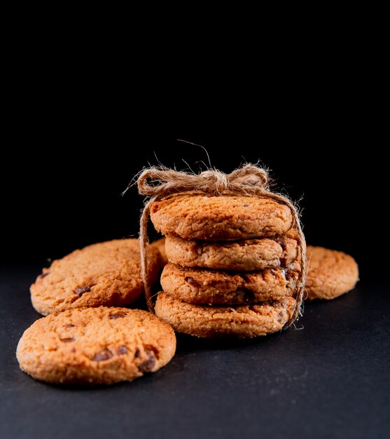 Biscotti di farina d'avena di vista frontale con cioccolato su una priorità bassa nera