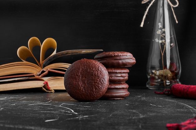 Biscotti di marshmallow al cioccolato sulla tavola nera.