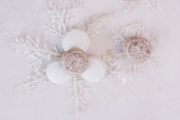 Biscotti di Natale con i fiocchi di neve sulla superficie bianca