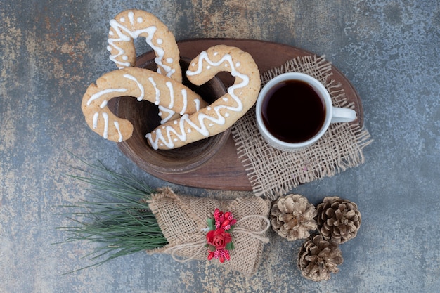 Biscotti di panpepato e tazza di tè con pigne nelle quali sulla tavola di marmo. Foto di alta qualità