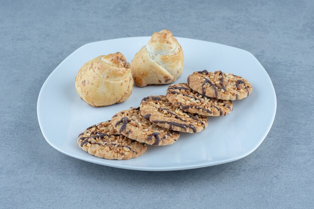 Biscotti di sesamo fresco sul piatto bianco. Foto ravvicinata.