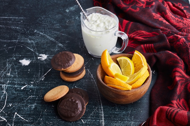 Biscotti di spugna al cioccolato in una tazza di legno con ricotta e arancia.