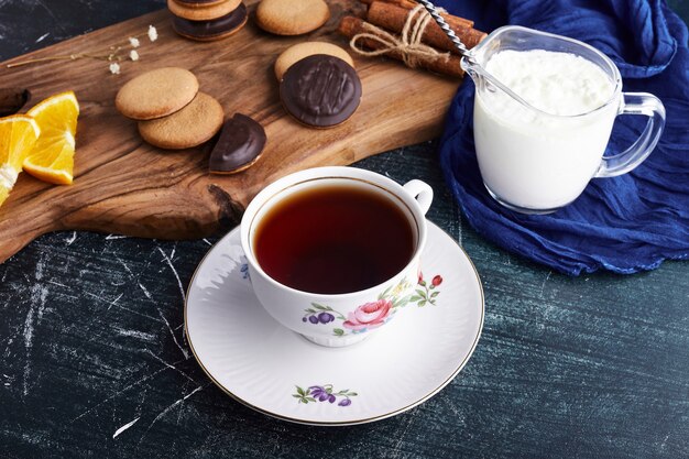 Biscotti di spugna al cioccolato su una tavola di legno con cagliata e tè.