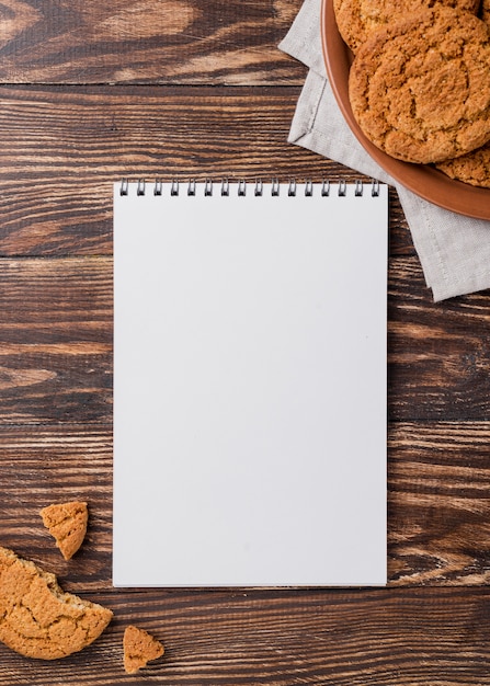 Biscotti di vista superiore e blocco note vuoto dello spazio della copia