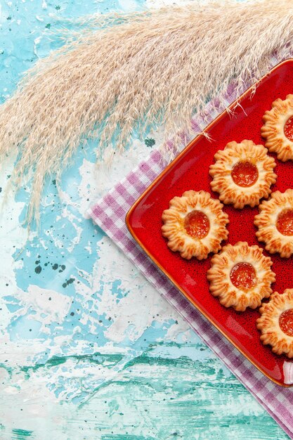 Biscotti di zucchero vista dall'alto all'interno del piatto rosso su sfondo blu