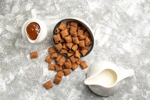 Biscotti dolci a cuscino vista dall'alto con salsa al cioccolato su bianco