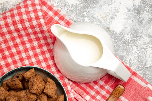 Biscotti dolci del cuscino di vista superiore sulla colazione bianca del latte dolce della scrivania?