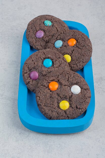 Biscotti dolci rotondi al cioccolato sulla zolla blu.