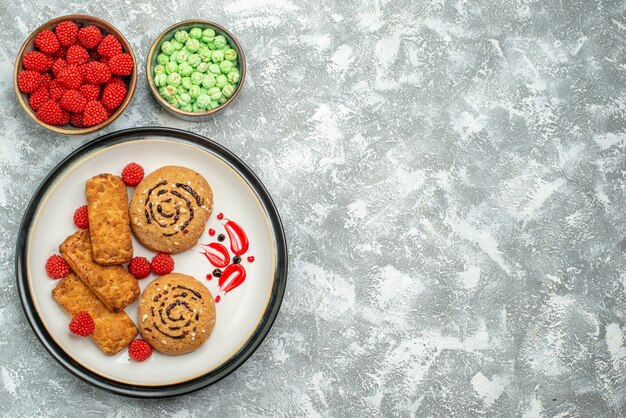 Biscotti dolci squisiti di vista superiore con le caramelle sul tè del biscotto della torta di zucchero dolce del biscotto del fondo bianco