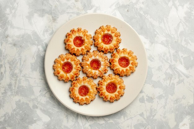 Biscotti dolci vista dall'alto con marmellata di arance su superficie bianca