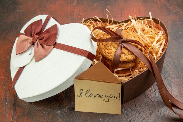 Biscotti dolci vista frontale come regalo con nota su sfondo scuro anello matrimonio sentimento coppia amore femminile colore regalo