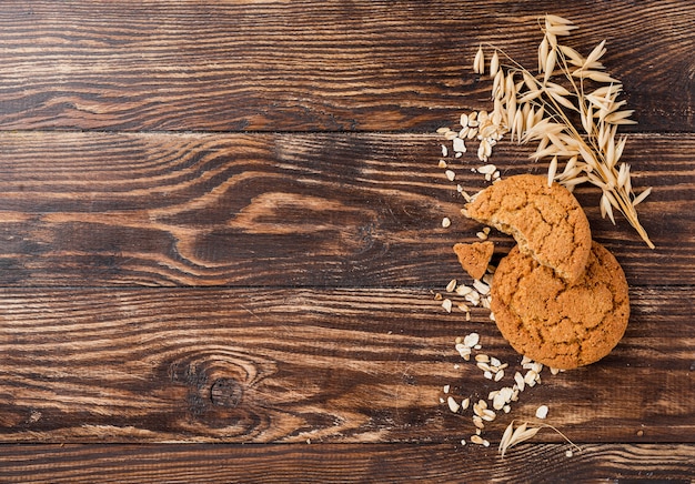 Biscotti e grano con il fondo di legno dello spazio della copia