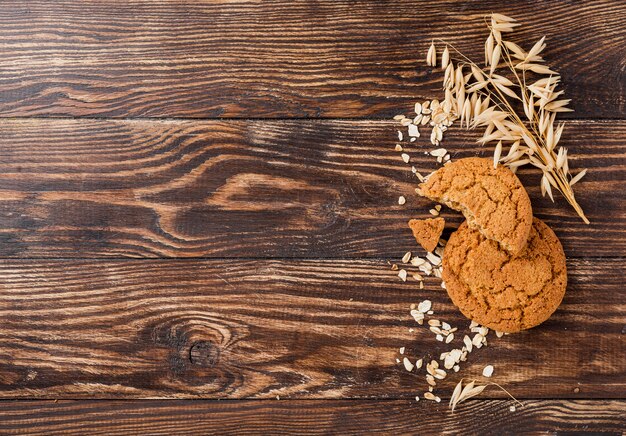 Biscotti e grano con il fondo di legno dello spazio della copia