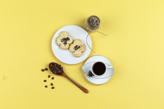 Biscotti e tazza di caffè su uno sfondo giallo