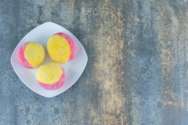 Biscotti fatti in casa a forma di pesca sul piatto, sulla superficie di marmo.