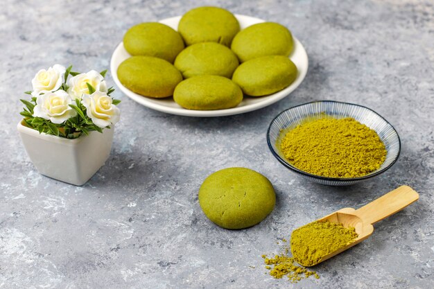 Biscotti fatti in casa del tè verde di matcha con la polvere di matcha sulla tavola di cemento grigia