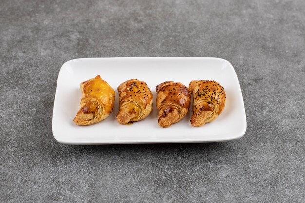 Biscotti fatti in casa di fila sul piatto bianco.