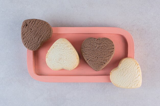 Biscotti fatti in casa freschi a forma di cuore sul piatto rosa