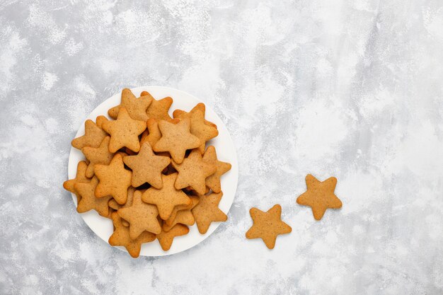 Biscotti fatti in casa tradizionali del pan di zenzero su calcestruzzo grigio, fine su, Natale, vista superiore, disposizione piana