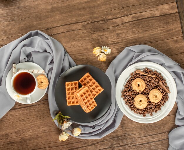 Biscotti in piattini bianchi e neri su un tavolo di legno