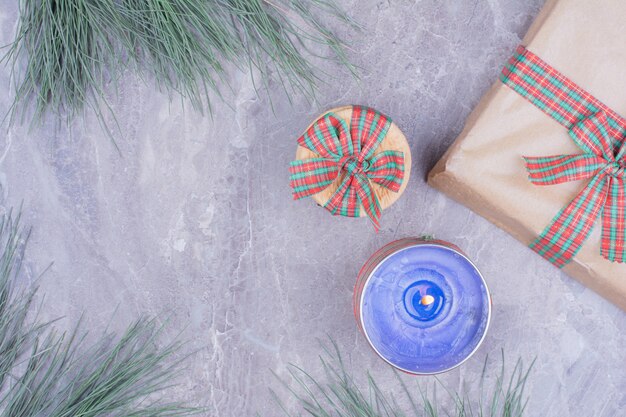 Biscotti in un involucro con una candela blu fiammeggiante e una confezione regalo intorno.