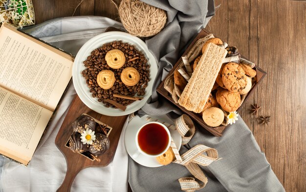 Biscotti misti, una tazza di tè e un libro