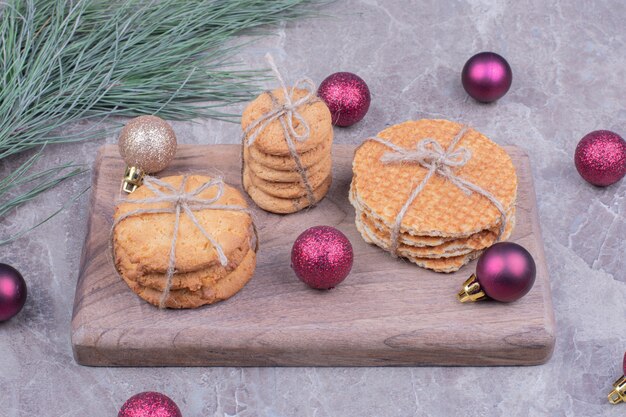 Biscotti su una tavola di legno con palle di Natale glitter rosso intorno