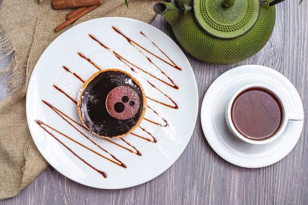 Biscotti vista dall'alto con gelatina di cioccolato e gelatina con una tazza di tè