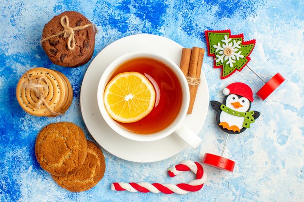 Biscotti vista dall'alto legati con una tazza di tè in corda dettagli di Natale sul tavolo blu