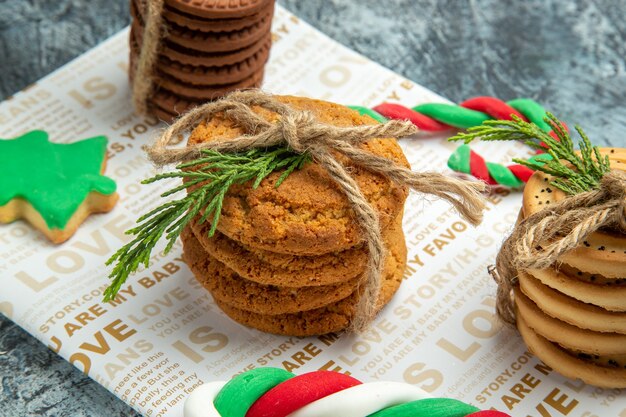 Biscotti vista frontale legati con una corda caramelle di natale su sfondo grigio foto di natale