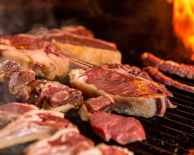 Bistecca che cucina su una griglia accanto alla fiamma