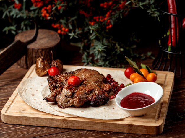 Bistecca di agnello guarnita con melograno, salsa acida e pomodoro