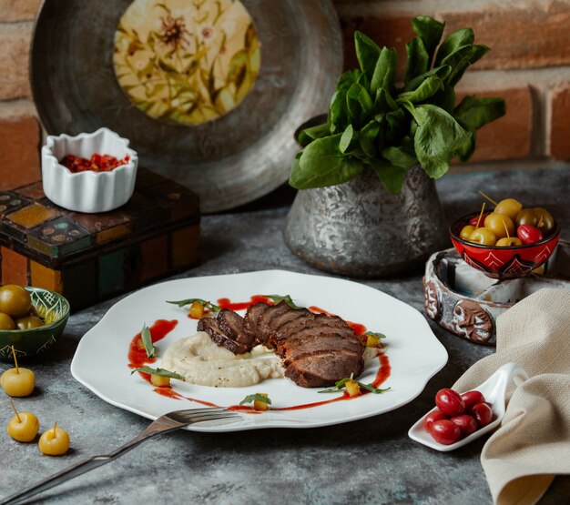 Bistecca di manzo tagliata finemente con contorno di riso e salsa di pomodoro