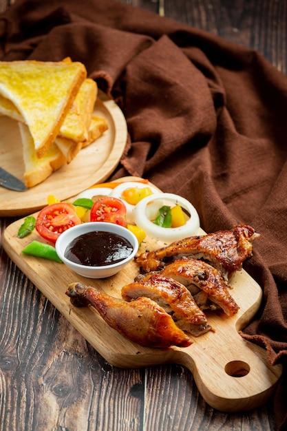 Bistecca di pollo alla griglia e verdure su fondo di legno scuro