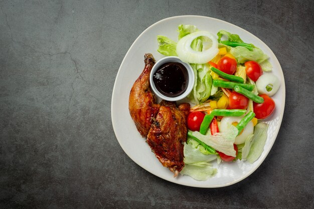 Bistecca di pollo alla griglia e verdure su sfondo scuro