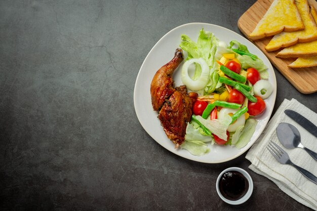 Bistecca di pollo alla griglia e verdure su sfondo scuro