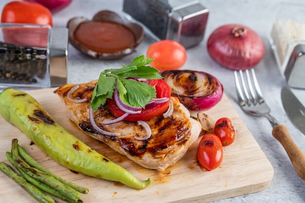 Bistecca di pollo disposta su un vassoio di legno.