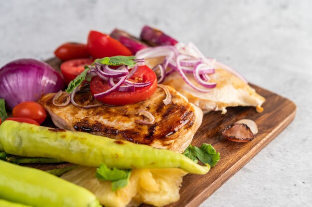 Bistecca di pollo disposta su un vassoio di legno.